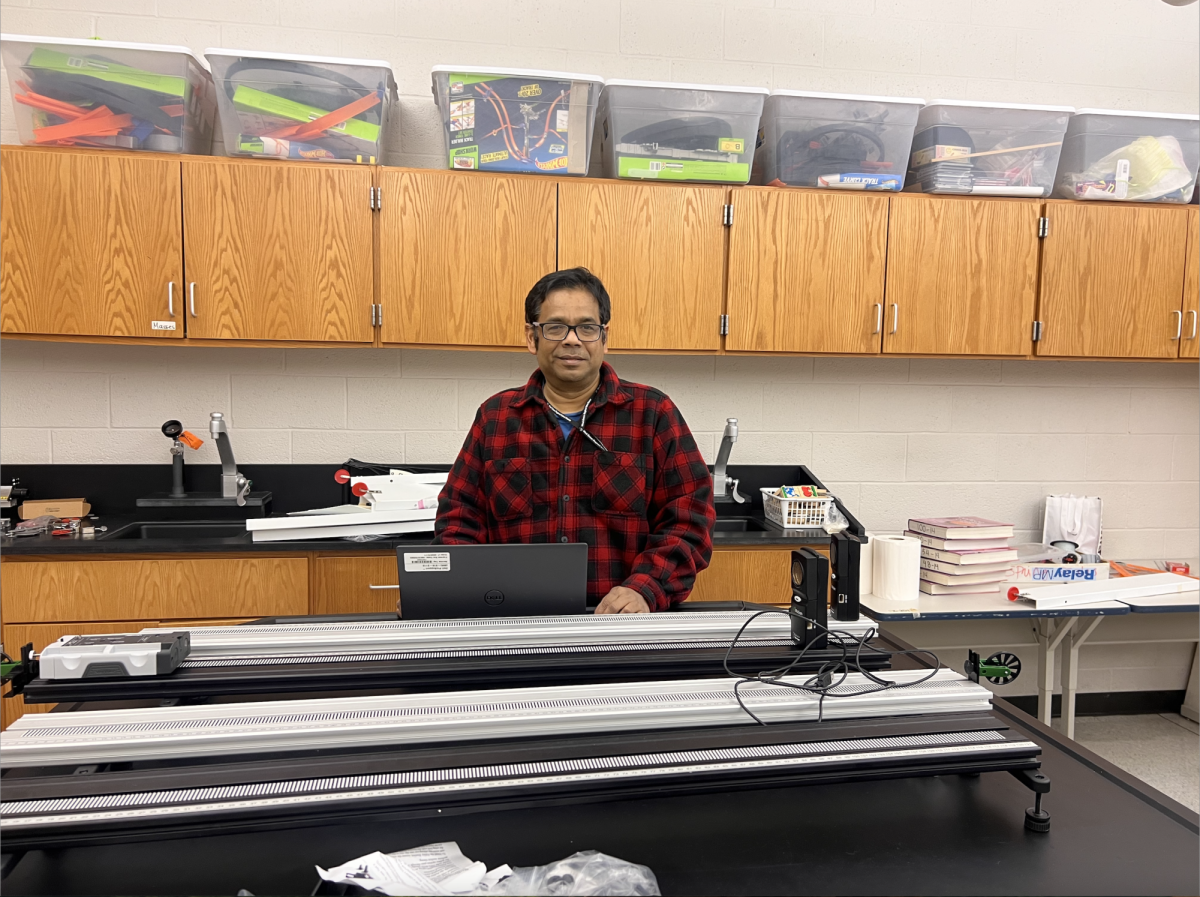 Physics teacher Dr. Rejwan Ali poses with his favorite lab equipment, which he enjoys sharing with students. 